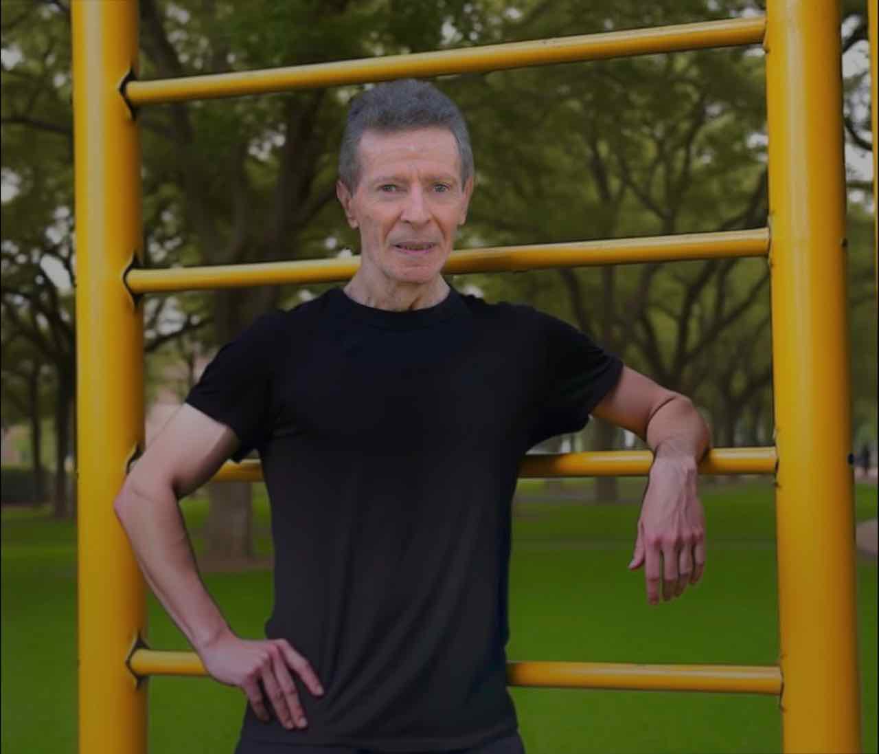 Carlos beside outdoor exercise bars